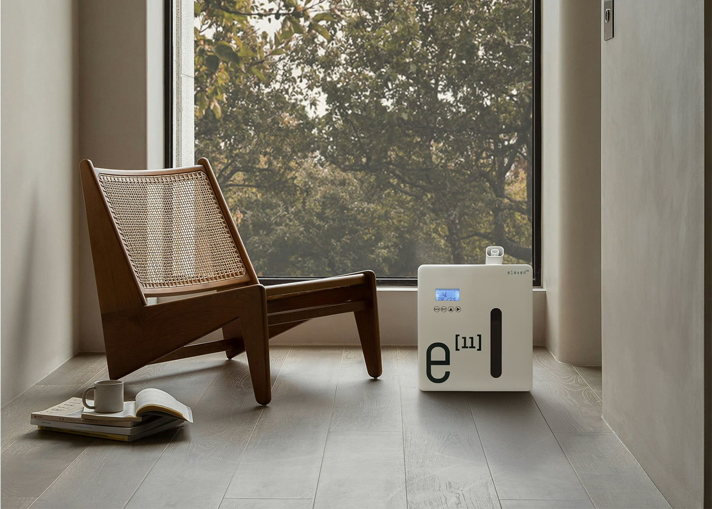 Sala com poltrona e difusor Eleven próximo à janela